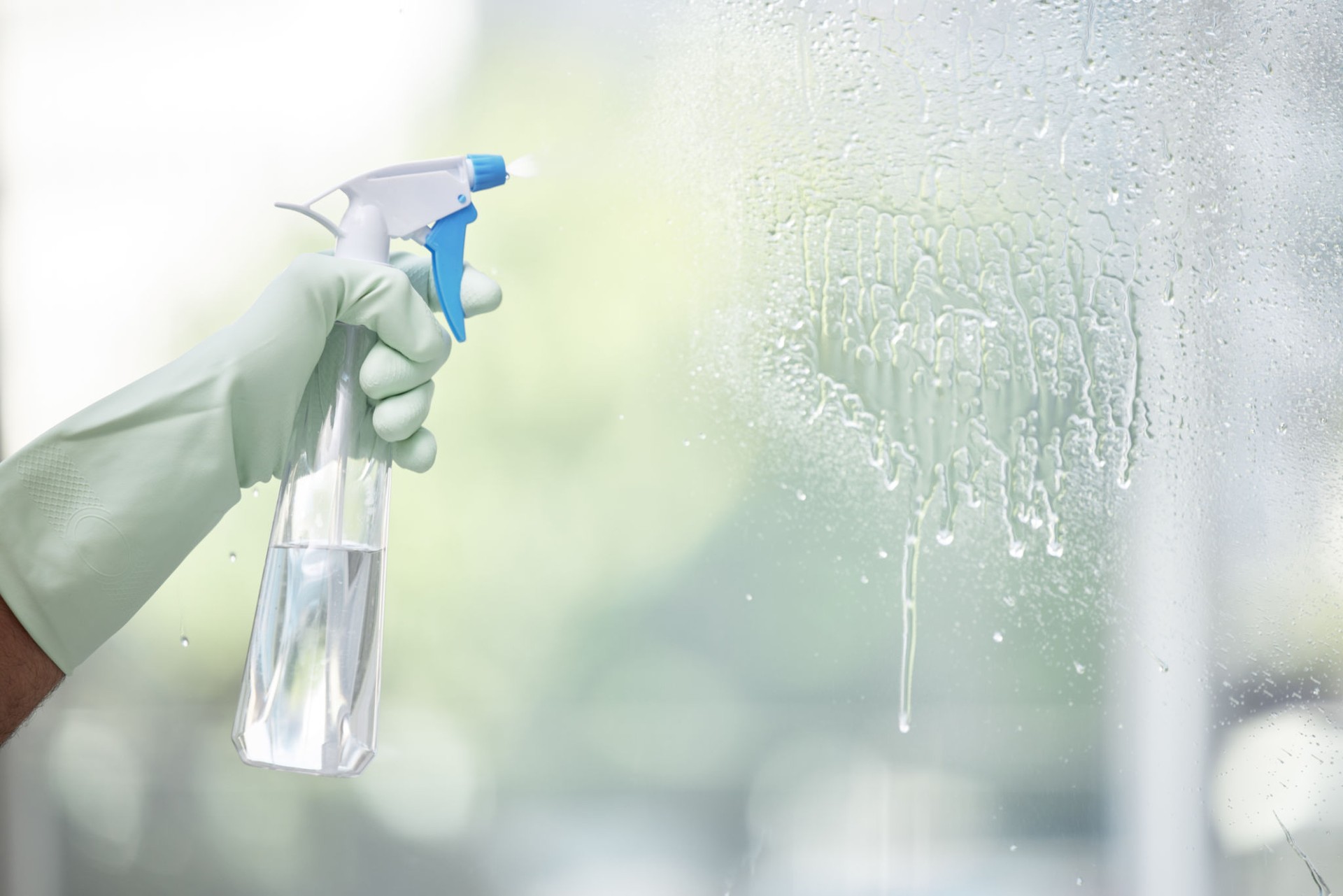 Shot of an unrecognizable person cleaning a glass window at home